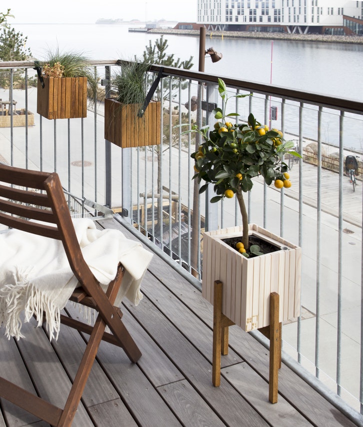 Conseil 10 astuces pour aménager son balcon. Balcon en bois avec jardinières de saison. 