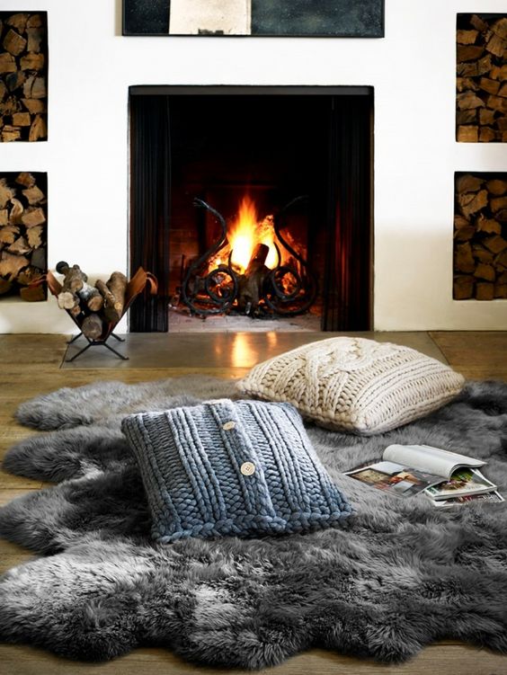 Utiliser des coussins de sols et des peaux de bêtes pour faire un coin cheminée de style cosy