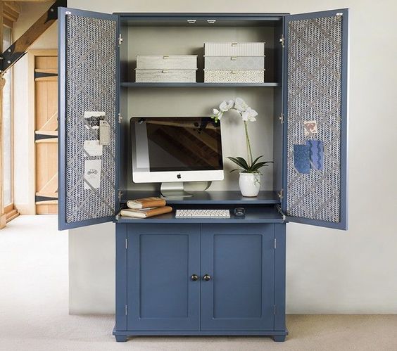 Une armoire transformée pour accueillir un ordinateur et des rangements de bureau. 