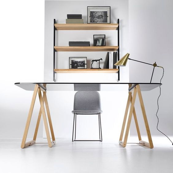Un bureau fait d'une planche en verre posée sur des tréteaux. Un style contemporain. 