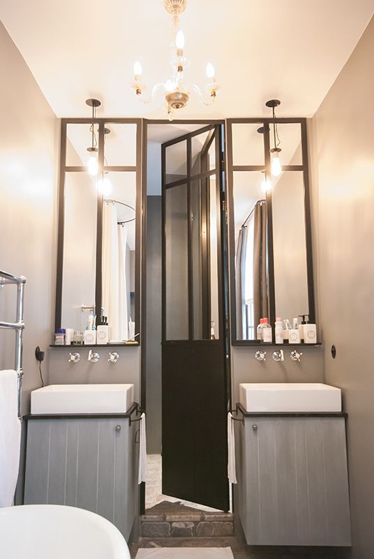 mur de miroirs dans une salle de bain et double vasque