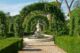 arche fleuri dans un jardin à l'italienne avec une fontaine
